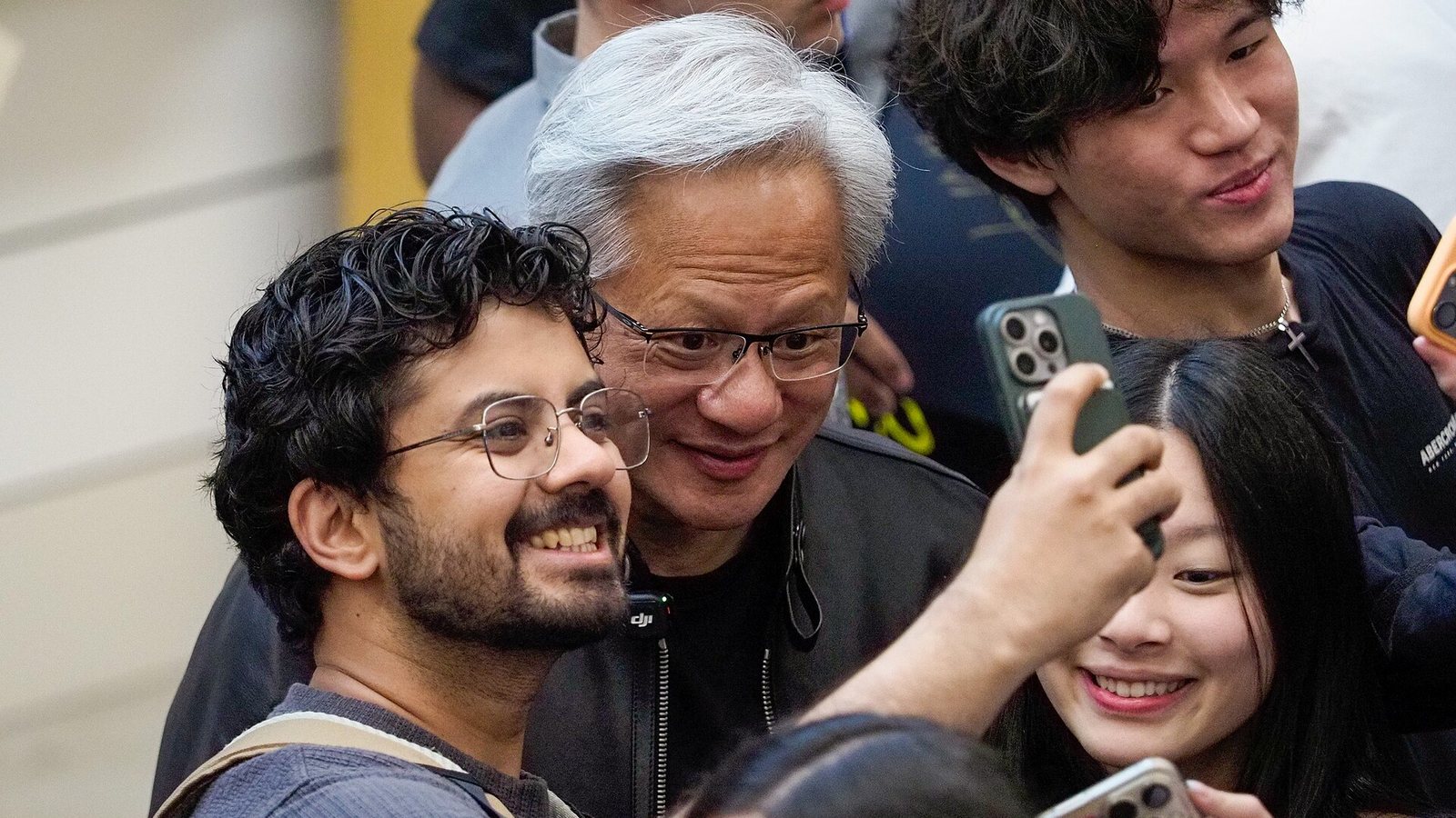 Jensen Huang, chief executive of NVIDIA, surrounded by students holding phones at a Stanford event in April 2026